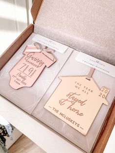 two pink and gold tags in a box