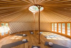 the inside of a yurt with yoga mats on the floor