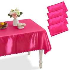 a pink table cloth with flowers and fruit on it next to a bowl of fruit