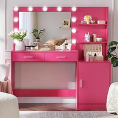 a pink vanity with lights on it in a room