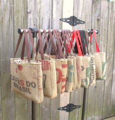 there are many bags hanging on the rack outside with ribbons attached to them and some scissors in each bag