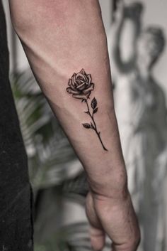 a black rose tattoo on the left arm