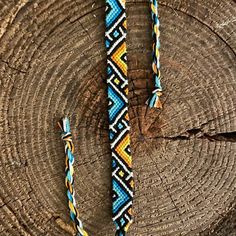 a blue, yellow and white beaded bracelet on a piece of wood