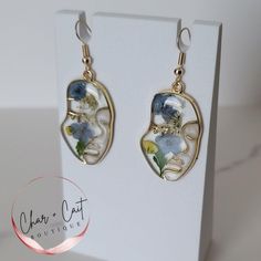 These elegant gold-tone abstract face earrings feature delicate pressed flowers encased in resin, creating a unique and artistic look. Lightweight and stylish, these earrings blend nature-inspired beauty with modern design, perfect for adding a touch of sophistication to any outfit. Size: Approx 3/4" wide and 1-1/2" long Comes with a reusable plastic case shown in the last photo. Orders are shipped within 1-2 business days.  General jewelry care - keep the item dry and away from moisture. All ph Resin Business, Face Outline, Real Flower Jewelry, Gold Face, Face Earrings, Abstract Face, Abstract Faces, Resin Flowers, Etsy Earrings Dangle