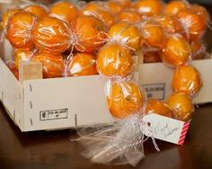 oranges wrapped in plastic sitting on top of a wooden table next to each other