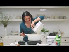 a woman is mixing something in a bowl