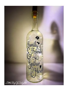 a glass bottle with the words family, friends and gather here written on it in black ink