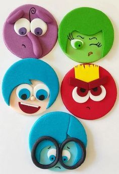 four different colored cartoon faces with scissors