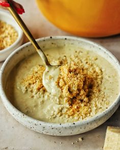 two bowls filled with dip and crackers on a table next to an orange pumpkin