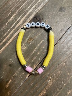 Description Show your appreciation for your favorite teacher with this fun and stretchy Teacher Clay Beaded Bracelet. Each side features colorful clay beads resembling a pencil, with the word TEACH in the center. Perfect as a gift for the teacher who never takes themselves too seriously! Details fits: 6.5" to 7" wrist disc shaped clay beads yellow, pink, gold spacer beads the Word TEACH in white and black Features One of a kind, fashion jewelry, everyday jewelry Great gift for that special girl, Bracelet For Teacher Gift Ideas, Black Clay Bracelet Ideas, Friends Themed Bracelets, Clay Bead Bracelet Ideas For Teachers, Clay Bead Apple Watch Band, Cute Bracelets With Clay Beads, Disc Bracelet Ideas, Multicolor Adjustable Beaded Bracelets For Teacher Appreciation, Adjustable Multicolor Beaded Bracelets For Teacher Appreciation