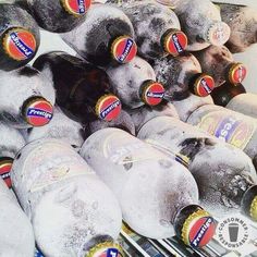 several bottles of beer are stacked on top of each other in a cooler filled with ice