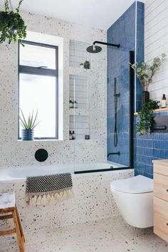 a bathroom with blue and white tiles on the walls