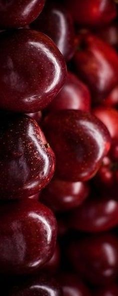 a pile of red grapes sitting next to each other