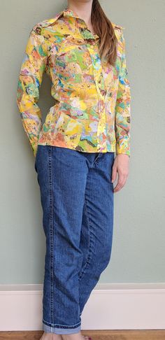 "This is a super groovy 1960's/1970s button-up marbled shirt with a strong psychedelic/acid trip feel. Perfect for a music festival, costume, or disco party! The shirt is nicely tailored and look great both tucked or untucked. The collar is very wide in classic 1970s style. Fabric and care tag has faded with age but this shirt feels and wears like polyester. It responded well to a hand laundering and light steaming to press and remove wrinkles. Fits like a modern small. In lovely vintage conditi Retro Tops With Abstract Print For Spring, Spring Fitted Blouse With Abstract Print, Fitted Shirt With Abstract Print For Spring, Fitted Cotton Blouse With Retro Print, Retro Spring Tops With Abstract Print, Retro Fitted Shirt For Spring, Fitted Retro Shirt For Spring, Vintage Tops With Abstract Print For Spring, 1970s Style Long Sleeve Shirt For Spring