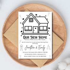 a new home card on top of a wooden plate next to cotton floss and an envelope