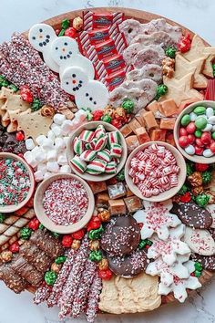 a platter filled with lots of different types of cookies and candies on top of each other