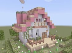 a small pink house in the middle of a field