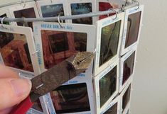 a person holding a knife in front of a bunch of pictures on a rack with magnets attached to it