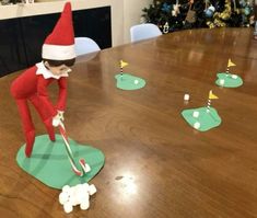 an elf is playing golf on the table with little white balls in front of him