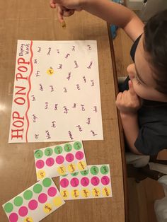 a young child sitting at a table with some writing on it