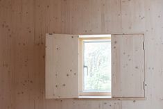 an open window on the side of a wooden wall