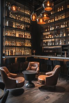 a bar with several chairs and bottles on the wall behind it, along with lights hanging from the ceiling