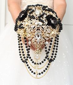 a close up of a person wearing a wedding dress holding a black and gold brooch