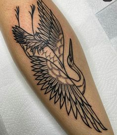 a black and white bird tattoo on the arm