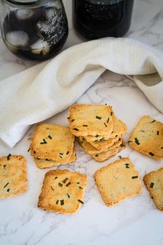 small crackers on a marble surface next to jars