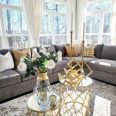 a living room filled with lots of furniture and flowers on top of a coffee table