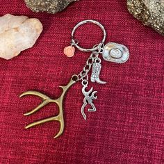 a close up of a keychain on a red cloth with rocks and stones