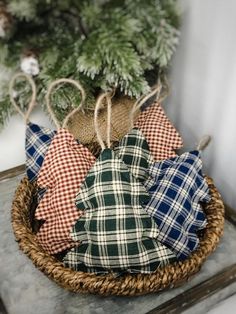 a basket filled with plaid fabric sitting on top of a table next to a christmas tree