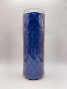 a blue glass vase sitting on top of a white table