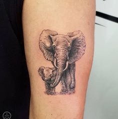 an elephant and her baby tattoo on the arm