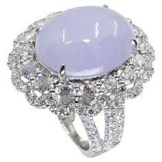 PLEASE CHECK OUT THE HD VIDEO! It not easy to find untreated lavender jade like this! This is certified natural light lavender purple jadeite Jade. Most lavender jade are treated to add color. The ring is set in 18k white gold and diamonds. There are 16 larger diamonds totaling 1.25cts and 90 smaller diamonds totaling 0.70cts in this setting. All in all a total of 1.95cts diamonds. The center of attention is the untreated and un-ehnanced lavender (purple) jadeite jade cabochon. The jade oval cabochon has a very desirable high dome. This center jade a light powder purple lavender color that is hard to find and in high demand. It is hard to capture this color in the photos. The untreated / unenhanced natural jade is translucent. The jade is full of life. The ring is very pleasing to the eyes Lavender Jade, Diamond Cocktail Ring, Light Lavender, Diamond Cocktail Rings, Ring Light, Jade Ring, Purple Lavender, Jade Jewelry, Natural Jade