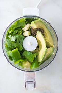 an avocado and lettuce in a food processor with a candle on top