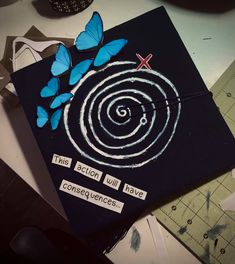 a black graduation cap with blue butterflies on it and writing underneath the caps reads, this fiction will have concentrics