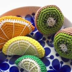 four crocheted fruits are on a plate