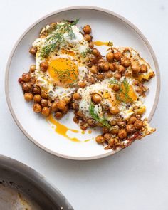 two eggs are on top of some chickpeas