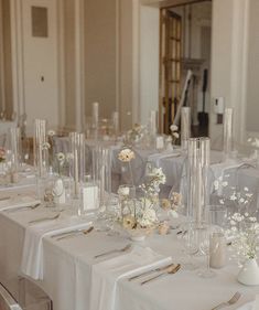 the tables are set with clear vases and flowers on them for an elegant wedding reception