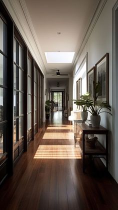 a long hallway with wooden flooring and large glass doors leading to the outside rooms