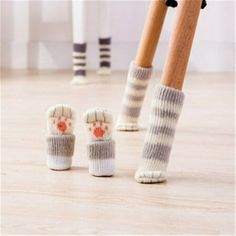 two pairs of socks with paw prints on them are next to a pair of legs