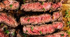 sliced steak on a cutting board with herbs