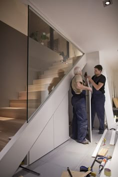 two men are working on the stair railing