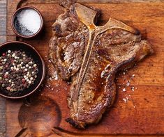 the steak is prepared and ready to be served on the table with spices, salt and pepper