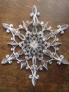 a metal snowflake sitting on top of a wooden table