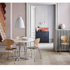 a dining room table and chairs in front of a colorful wall