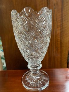 a clear glass vase sitting on top of a wooden table