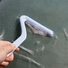 a person holding a toothbrush on top of a blackboard covered in white stuff