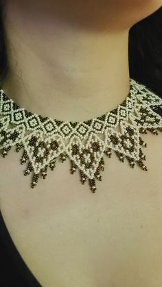 a close up of a woman wearing a necklace with pearls on the bottom and sides